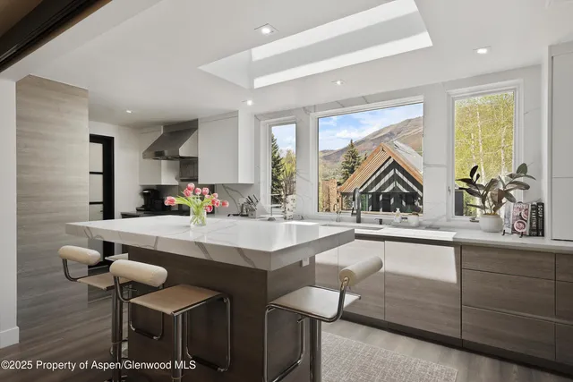 a kitchen with a sink and chairs