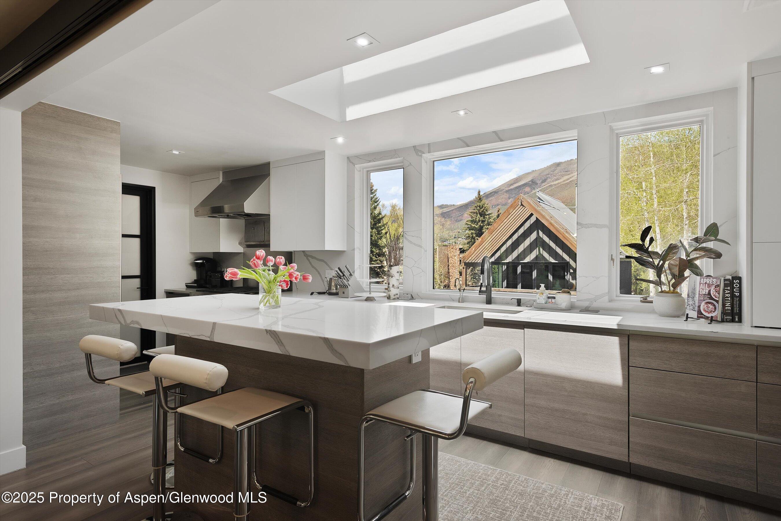 120 South Spring Street, Unit 1 Aspen, CO 81611 - Photo 9 of 37 a kitchen with a sink and chairs