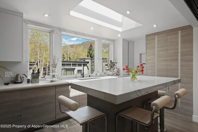 a kitchen with a table chairs sink and cabinets
