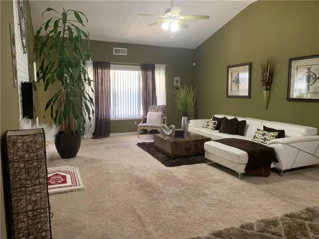 a living room with furniture and a potted plant