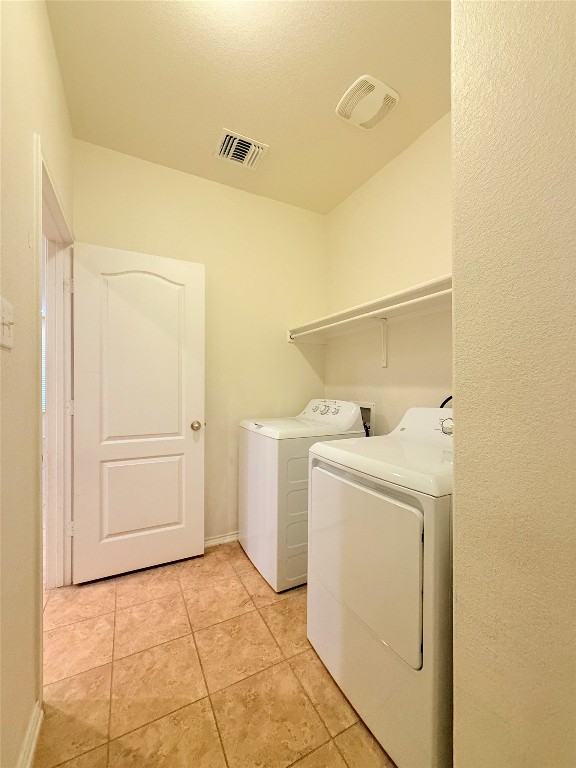 1140 Yellow Iris Road Leander, TX 78641 - Photo 13 of 23 Laundry room featuring washing machine and clothes dryer and light tile patterned floors