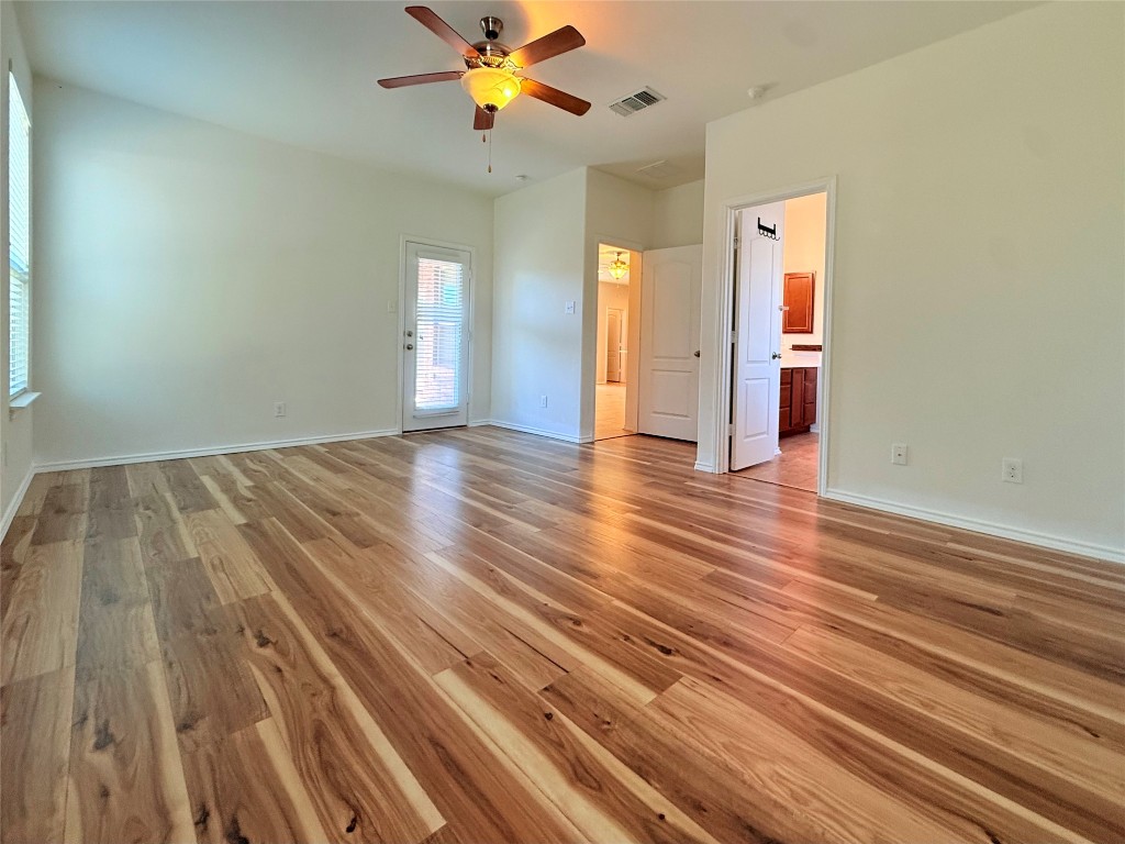 1140 Yellow Iris Road Leander, TX 78641 - Photo 14 of 23 Unfurnished bedroom with light wood-type flooring, a ceiling fan, and ensuite bathroom