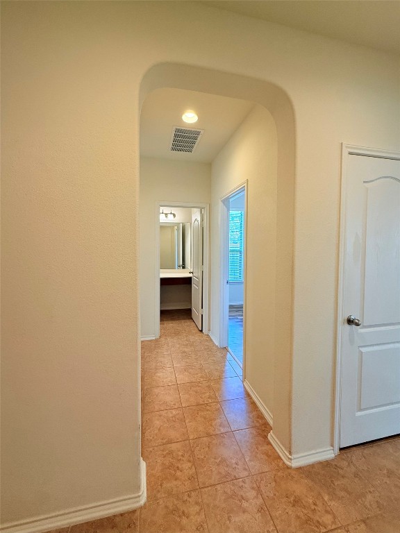 1140 Yellow Iris Road Leander, TX 78641 - Photo 16 of 23 Hallway featuring arched walkways and light tile patterned flooring