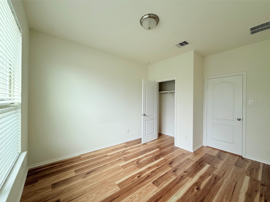 1140 Yellow Iris Road Leander, TX 78641 - Photo 18 of 23 Unfurnished bedroom featuring light wood-type flooring and a closet