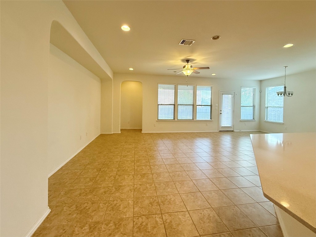 1140 Yellow Iris Road Leander, TX 78641 - Photo 3 of 23 Empty room featuring arched walkways, recessed lighting, a ceiling fan, light tile patterned floors, and a chandelier