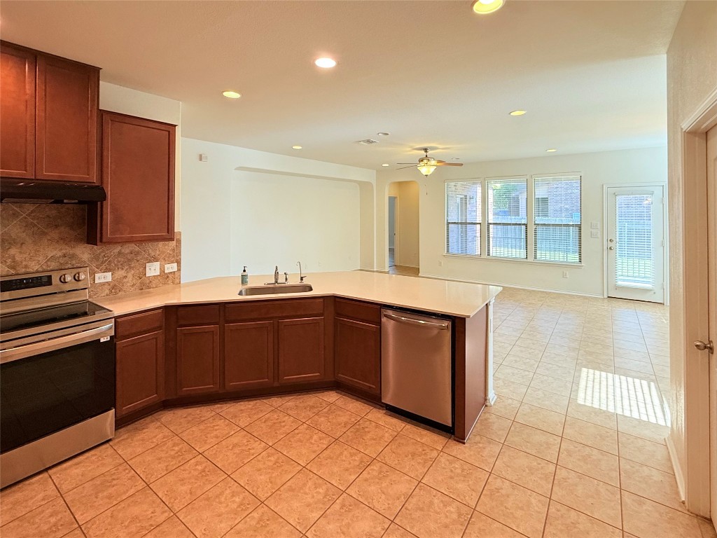 1140 Yellow Iris Road Leander, TX 78641 - Photo 23 of 23 Kitchen with appliances with stainless steel finishes, a peninsula, recessed lighting, backsplash, and open floor plan