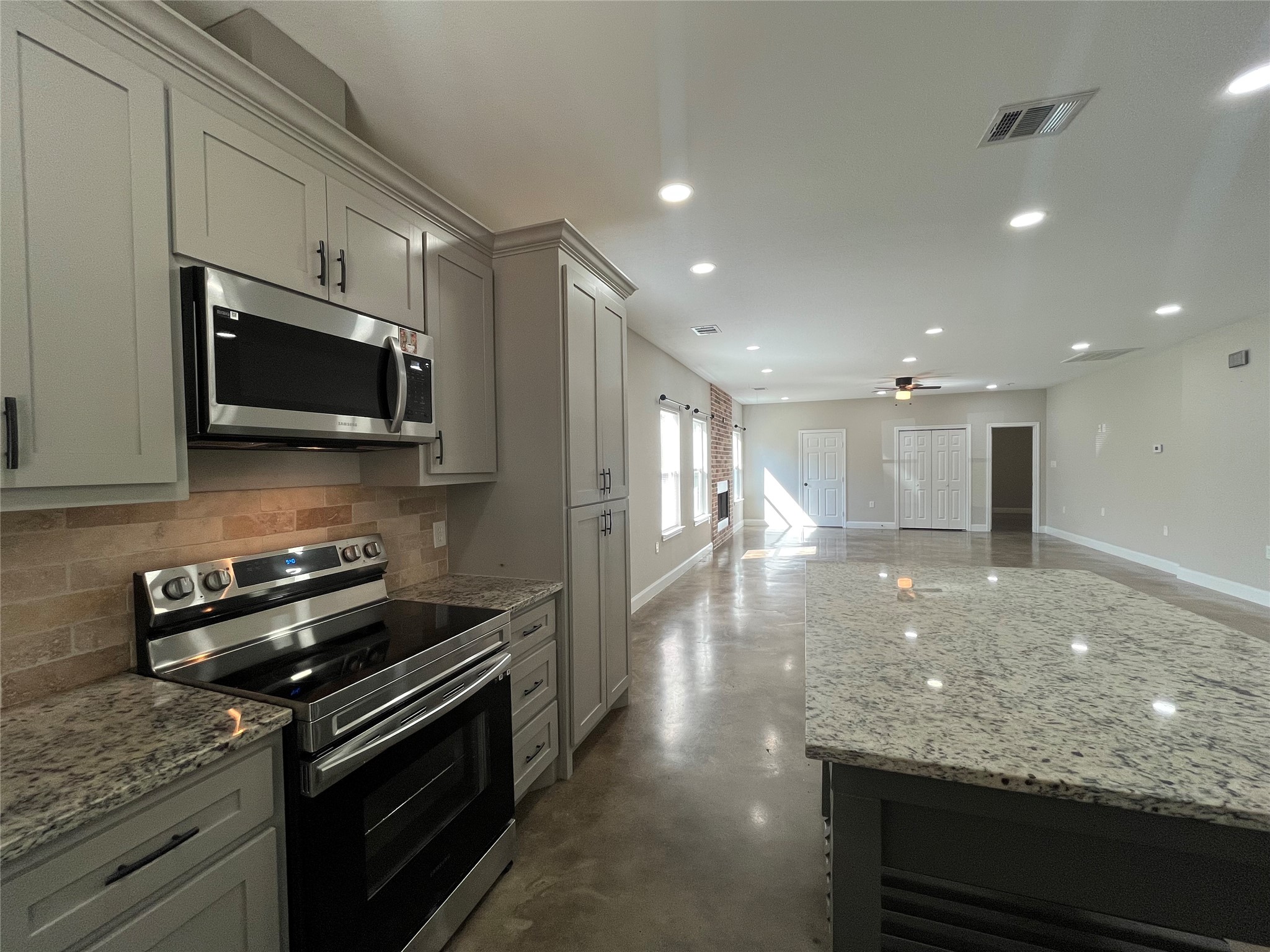 30023 Rosebud Street Magnolia, TX 77354 - Photo 1 of 21 a kitchen with stainless steel appliances kitchen island granite countertop a stove and a microwave