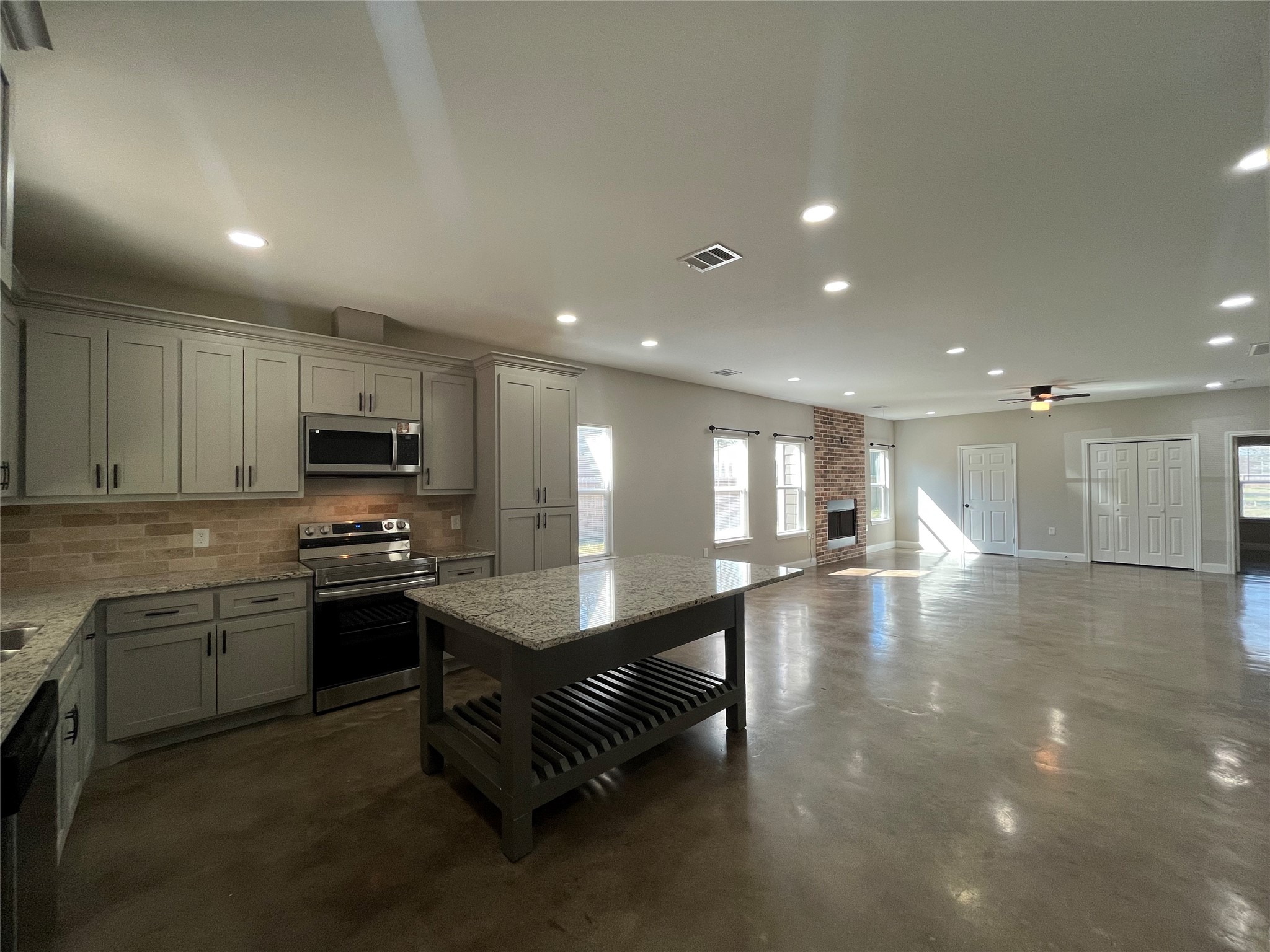 30023 Rosebud Street Magnolia, TX 77354 - Photo 6 of 21 a kitchen with stainless steel appliances a sink a stove a microwave a refrigerator and cabinets