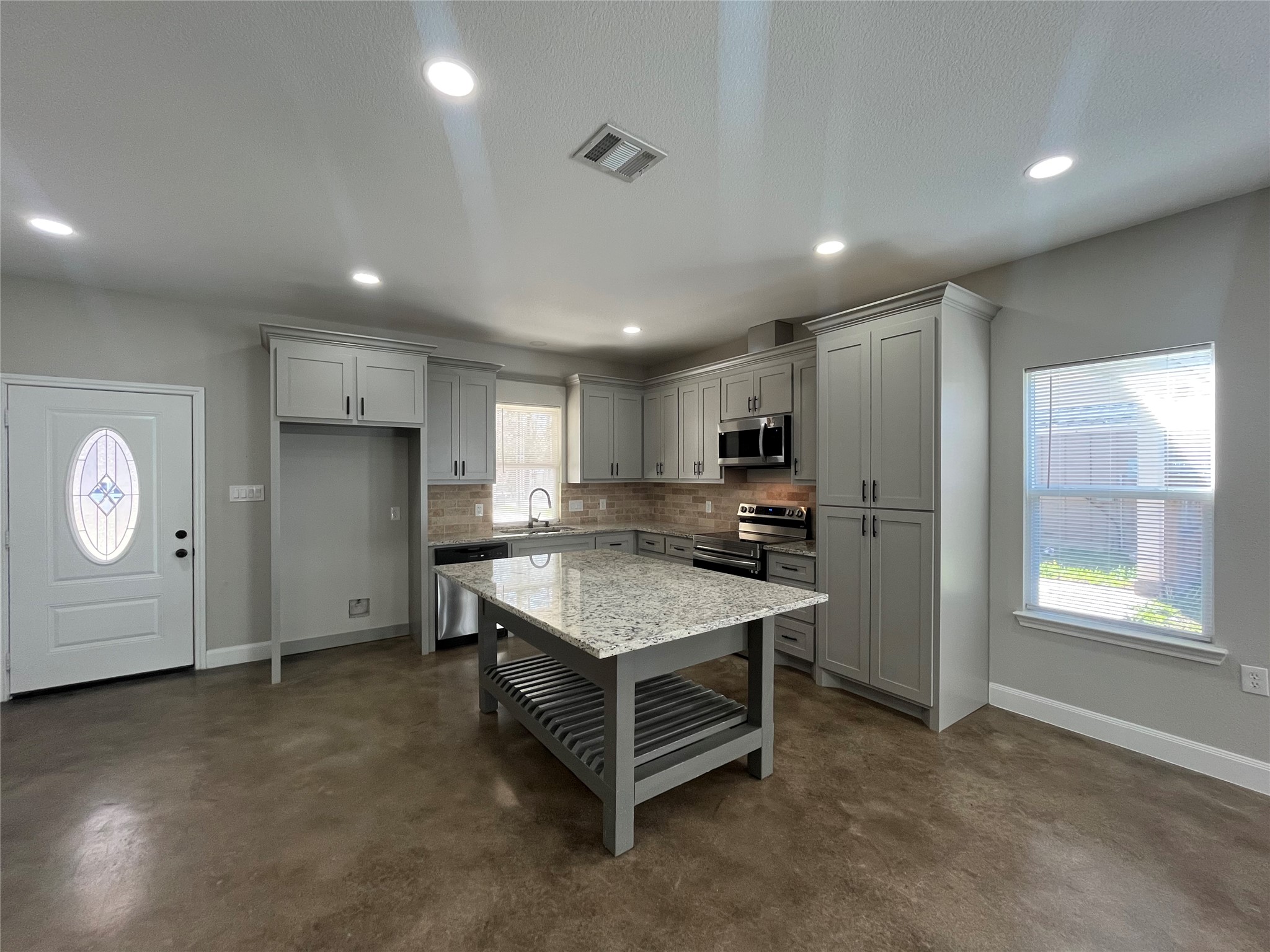30023 Rosebud Street Magnolia, TX 77354 - Photo 9 of 21 a room with kitchen island a sink wooden floor and stainless steel appliances