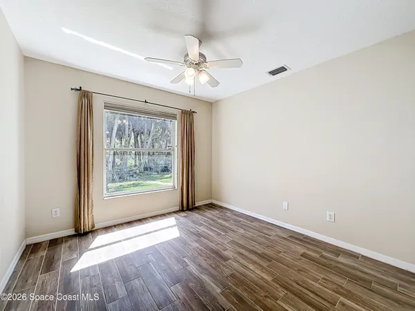 wooden floor in an empty room with a window