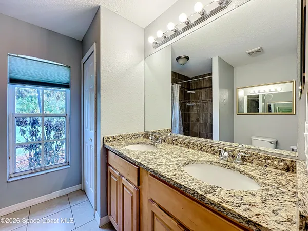 a bathroom with a granite countertop sink and a large mirror