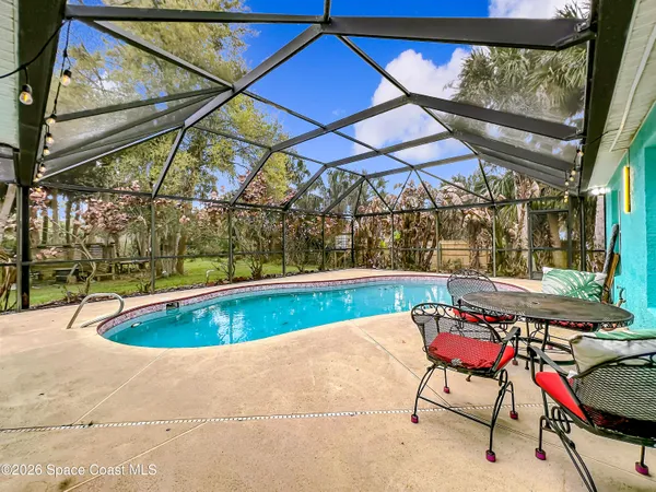 a view of patio with a table and chairs under an umbrella