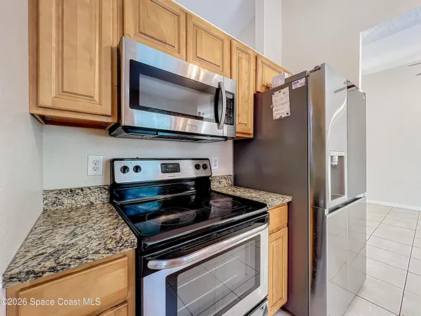 a kitchen with stainless steel appliances granite countertop a stove microwave and refrigerator