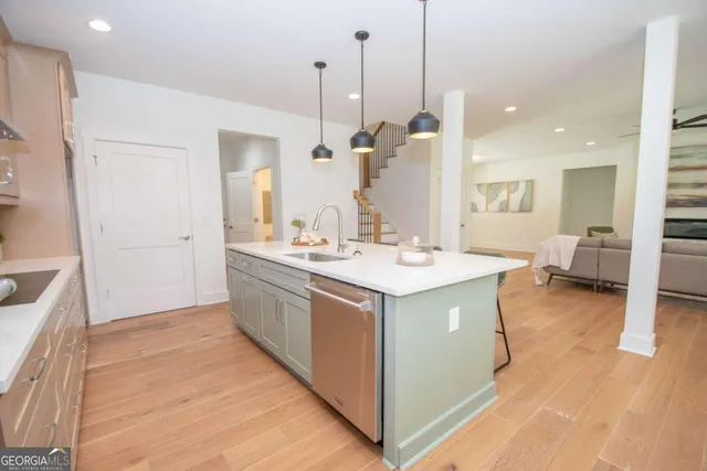 a view of kitchen with stainless steel appliances kitchen island sink and wooden floor