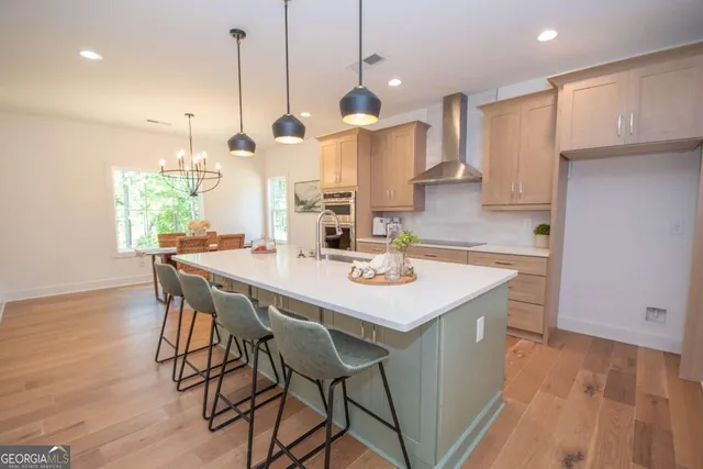 a kitchen with stainless steel appliances kitchen island granite countertop a table chairs and a refrigerator