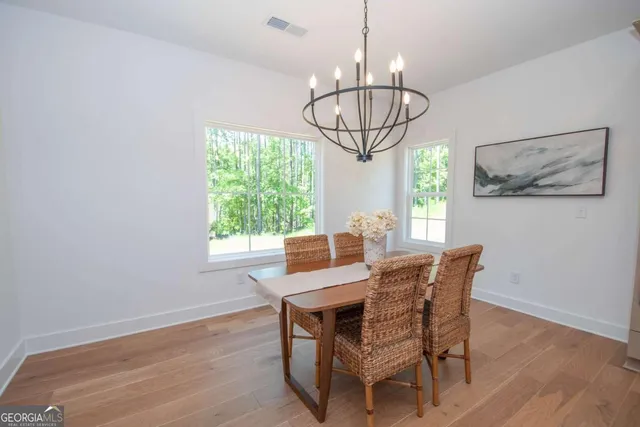 a view of a dining room with furniture wooden floor and chandelier