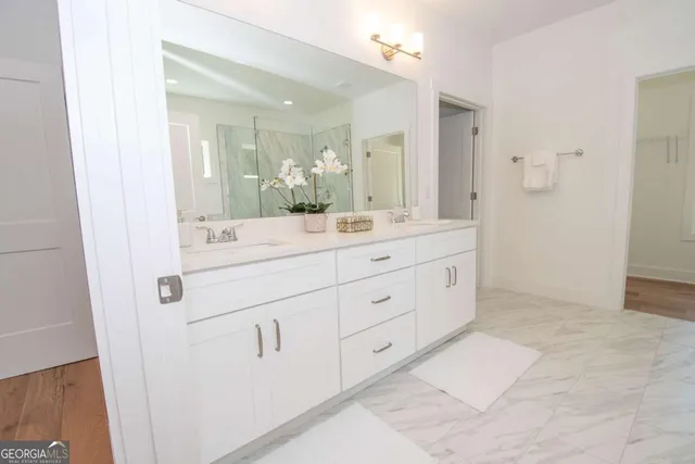 a bathroom with a shower sink and mirror