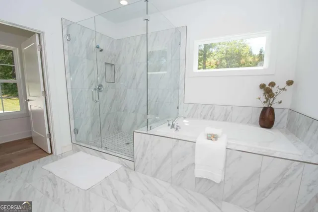 a bathroom with a tub sink a mirror and a shower