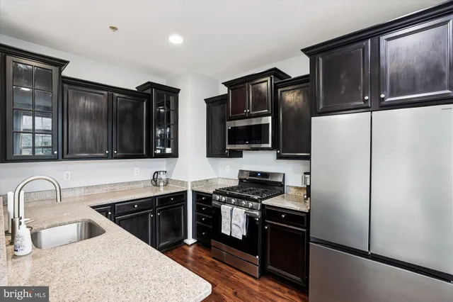 a kitchen with granite countertop stainless steel appliances and refrigerator