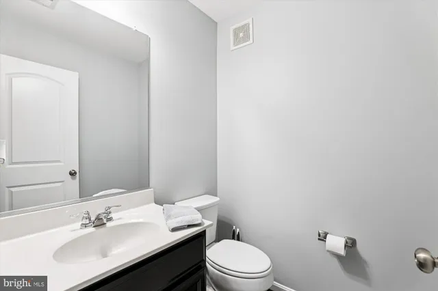 a bathroom with a sink vanity mirror and toilet