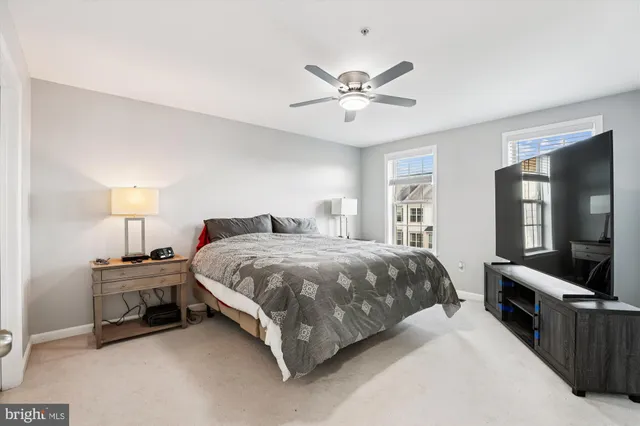 a spacious bedroom with a bed and a flat screen tv