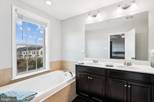 a bathroom with a tub sink and mirror