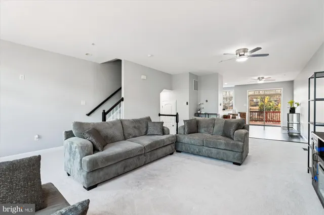 a living room with furniture and a ceiling fan