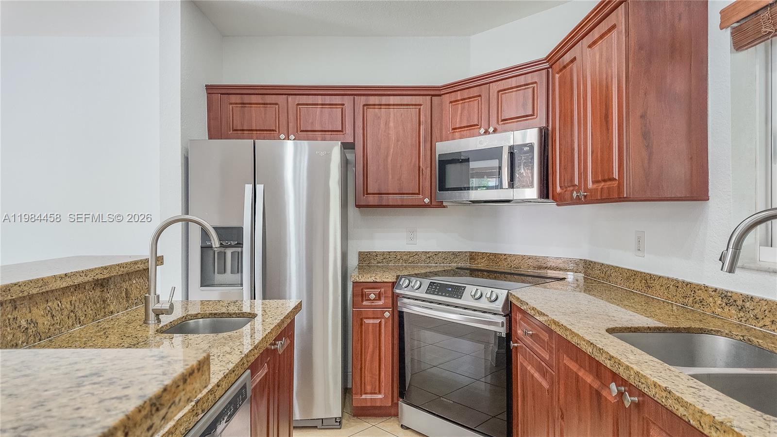 6002 Southwest 8th Street, Unit 3 West Miami, FL 33144 - Photo 2 of 10 a kitchen with stainless steel appliances granite countertop a sink stove and refrigerator