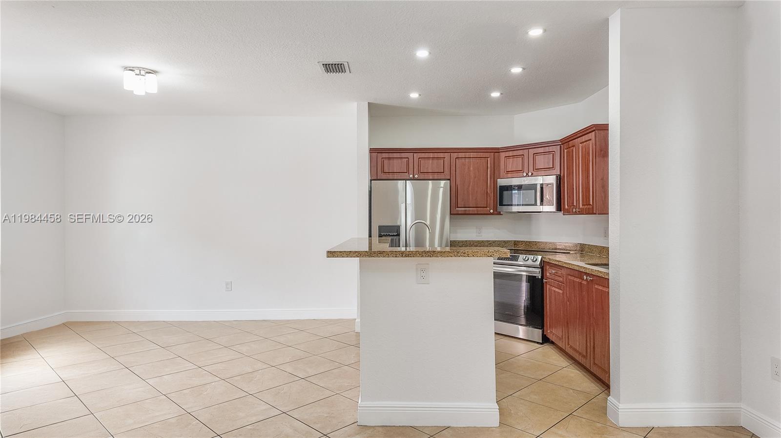 6002 Southwest 8th Street, Unit 3 West Miami, FL 33144 - Photo 3 of 10 a kitchen with stainless steel appliances granite countertop a stove and a refrigerator