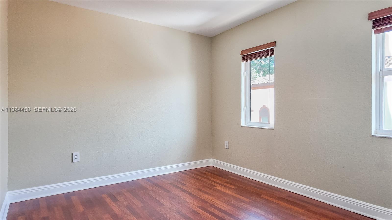 6002 Southwest 8th Street, Unit 3 West Miami, FL 33144 - Photo 9 of 10 an empty room with wooden floor and windows