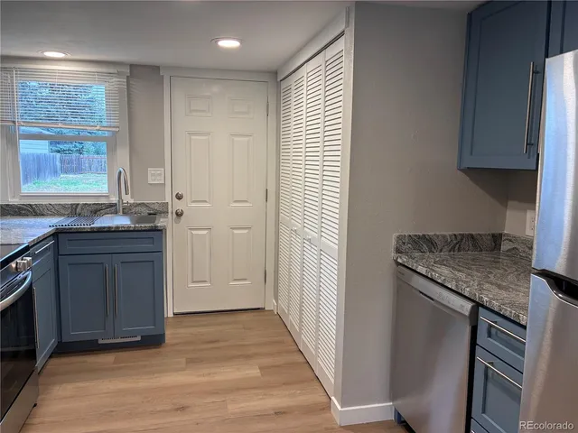 a kitchen with granite countertop stainless steel appliances a sink stove and cabinets