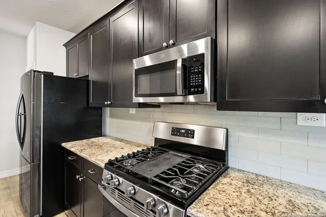 a kitchen with stainless steel appliances granite countertop a sink stove and refrigerator