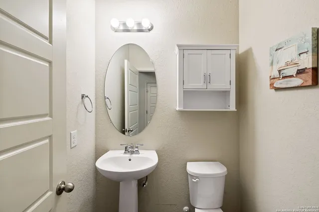 a bathroom with a toilet sink and mirror