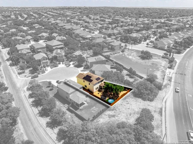 an aerial view of residential houses with outdoor space and trees all around