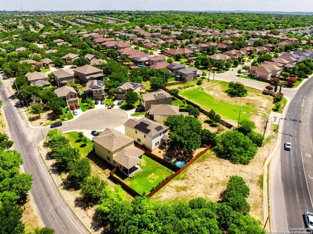 an aerial view of residential houses with outdoor space and street view