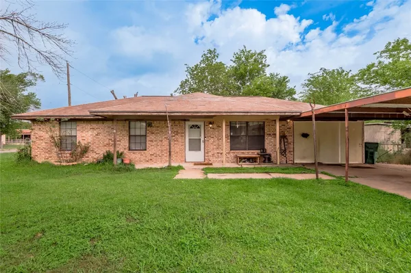 a front view of a house with a garden and yard