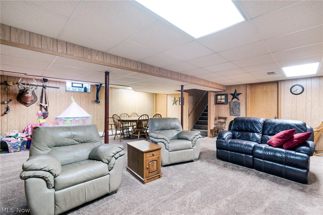 11711 Bandy Road Alliance, OH 44601 - Photo 42 of 50 Carpeted living room featuring wooden walls and a drop ceiling