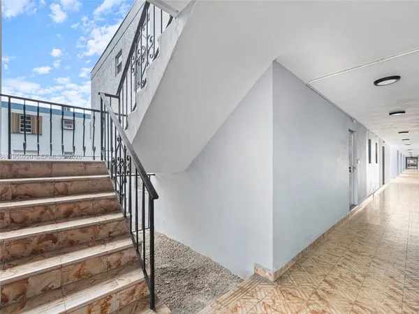 a view of staircase with railing and white walls