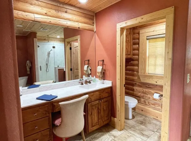 a bathroom with a granite countertop sink toilet and shower