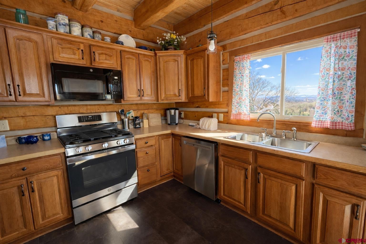 6493 Townsend Road Delta, CO 81416 - Photo 7 of 38 a kitchen with wooden cabinets and a stove top oven