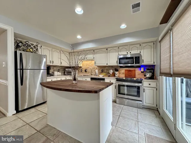 a kitchen with stainless steel appliances granite countertop a refrigerator sink and cabinets