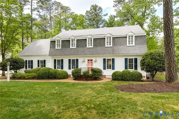 a front view of a house with a yard and trees