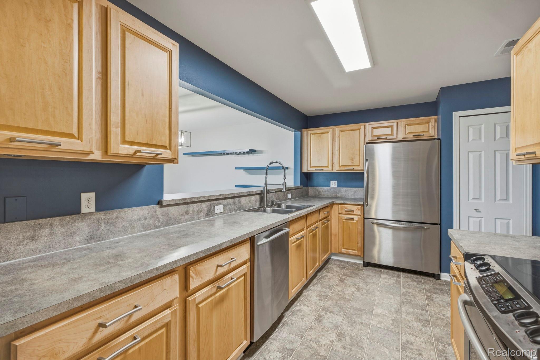 1905 Flagstone Circle Rochester, MI 48307 - Photo 16 of 33 Kitchen featuring wood cabinetry, stainless steel appliances, a double basin sink, and tile flooring