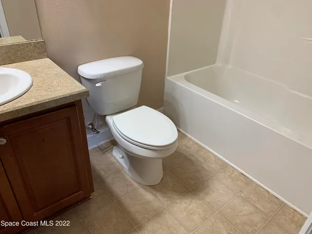 a white toilet sitting next to a bath tub