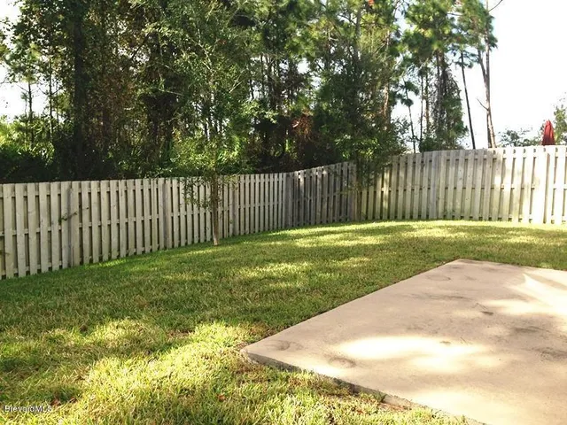 a view of a backyard with fence