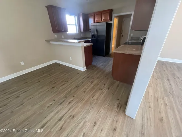 a kitchen with a refrigerator sink and cabinets
