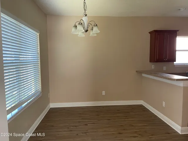 a view of a room with wooden floor and cabinets
