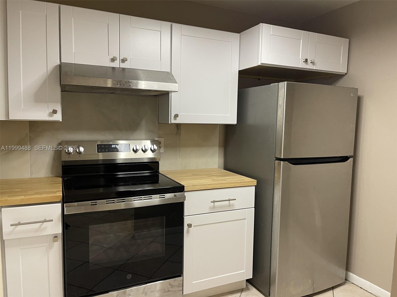 1250 Lincoln Road, Unit 306 Miami Beach, FL 33139 - Photo 6 of 12 a kitchen with stainless steel appliances white cabinets and a stove
