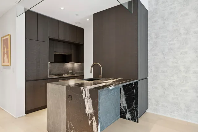 a living room with couches and kitchen view with wooden floor