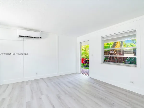 an empty room with window and wooden floor
